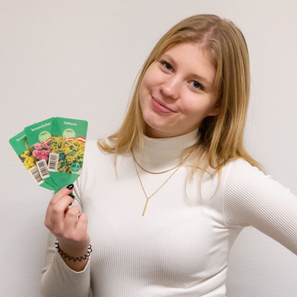 Lizzy showing plant labels printed on our biopolymer paper